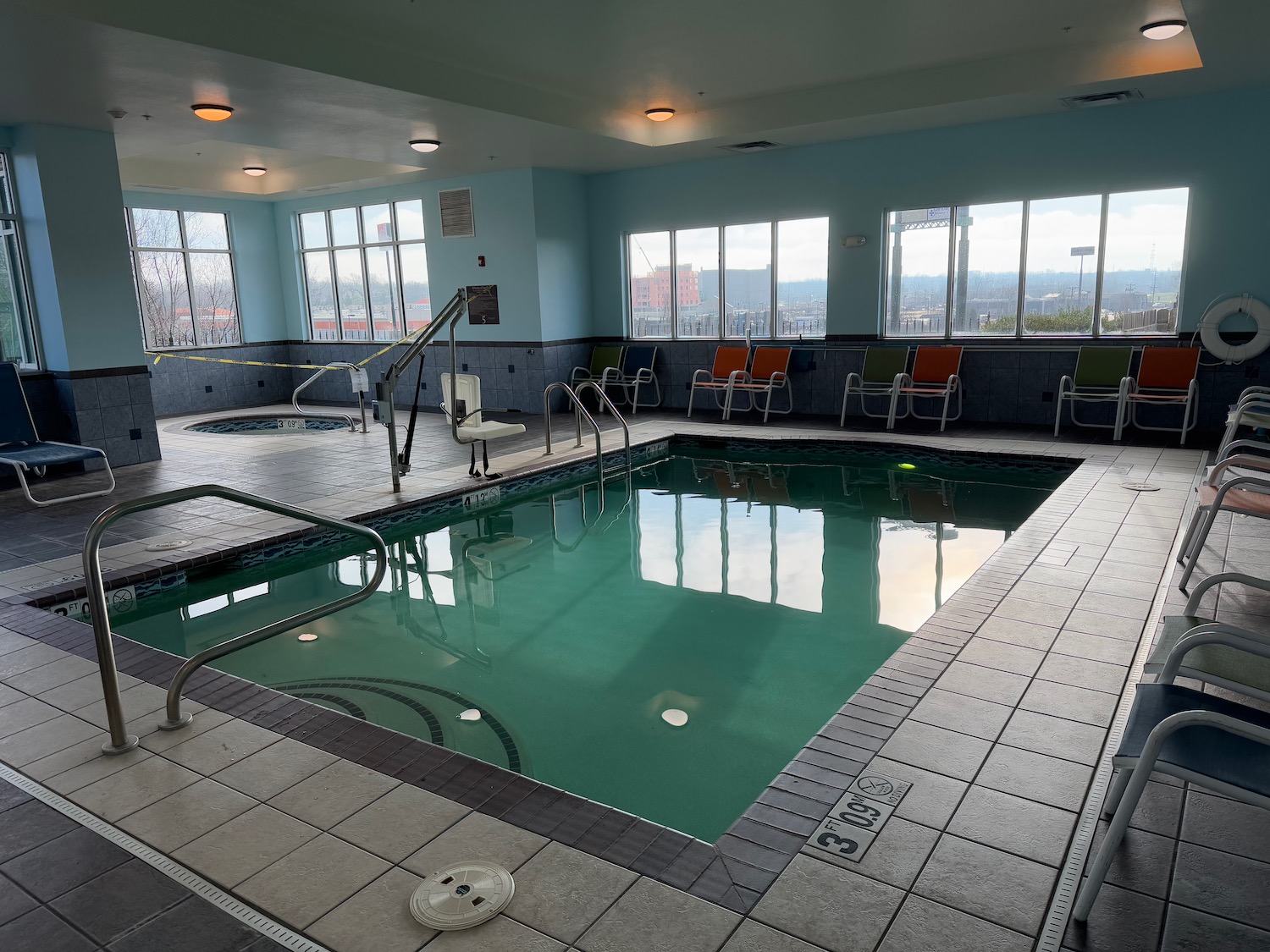 a indoor pool with chairs and a railing