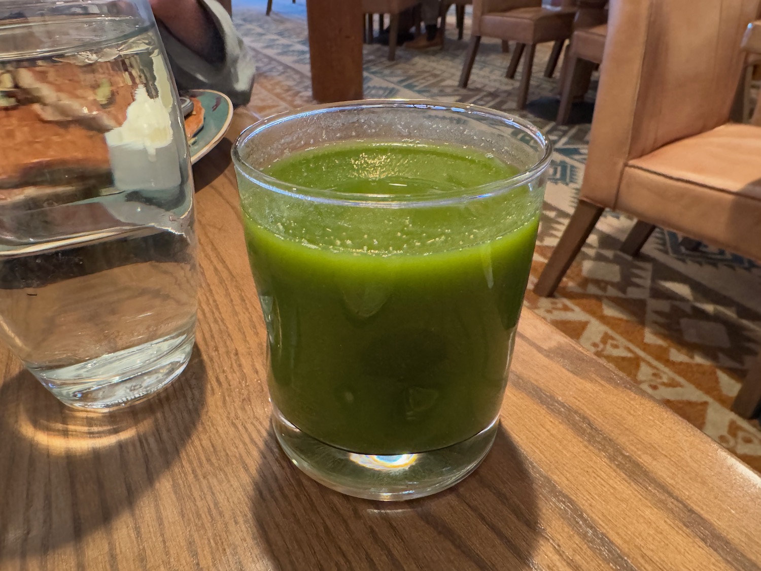 a glass of green liquid on a table