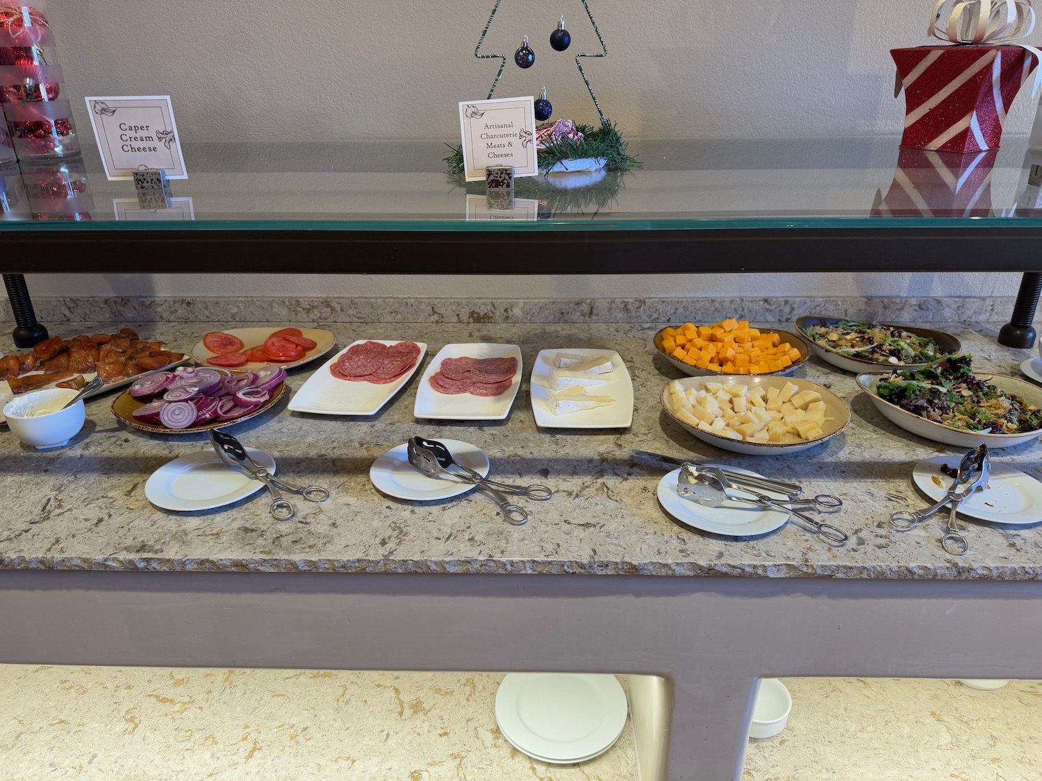 a buffet table with plates of food and spoons