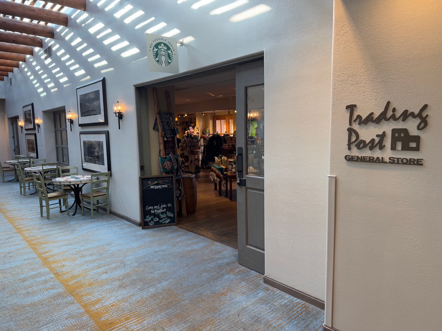 a storefront with a sign and tables and chairs