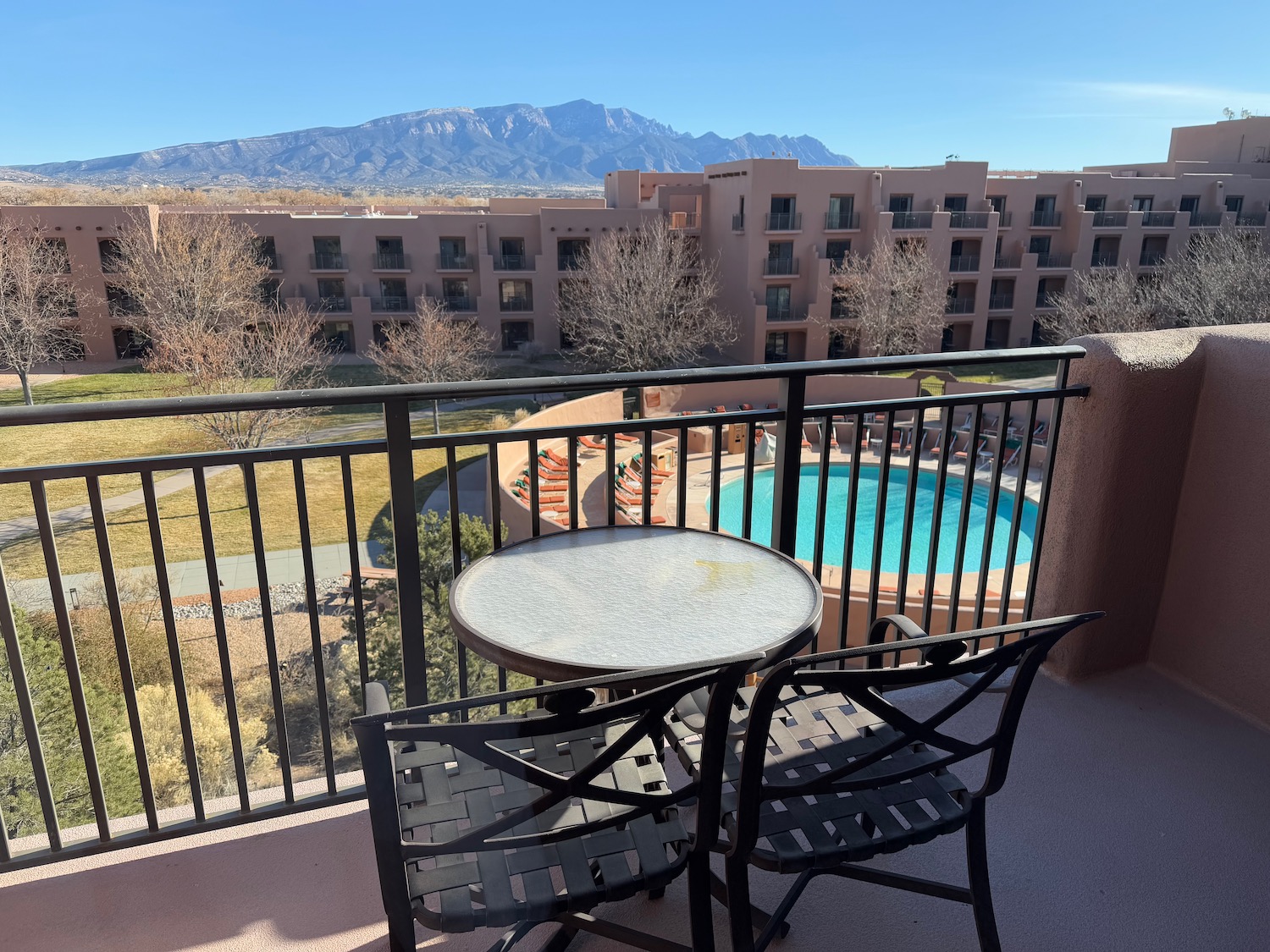 a table and chairs on a balcony overlooking a pool