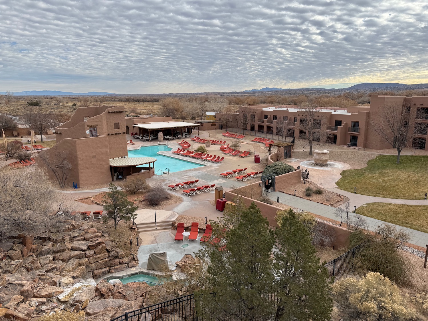 a pool and buildings with trees and grass