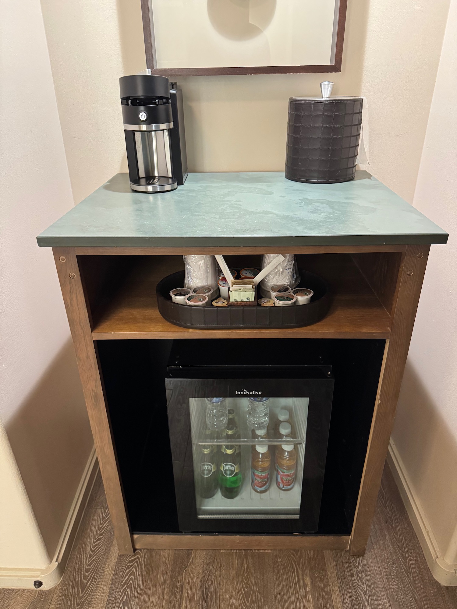 a small table with a mini fridge and coffee maker