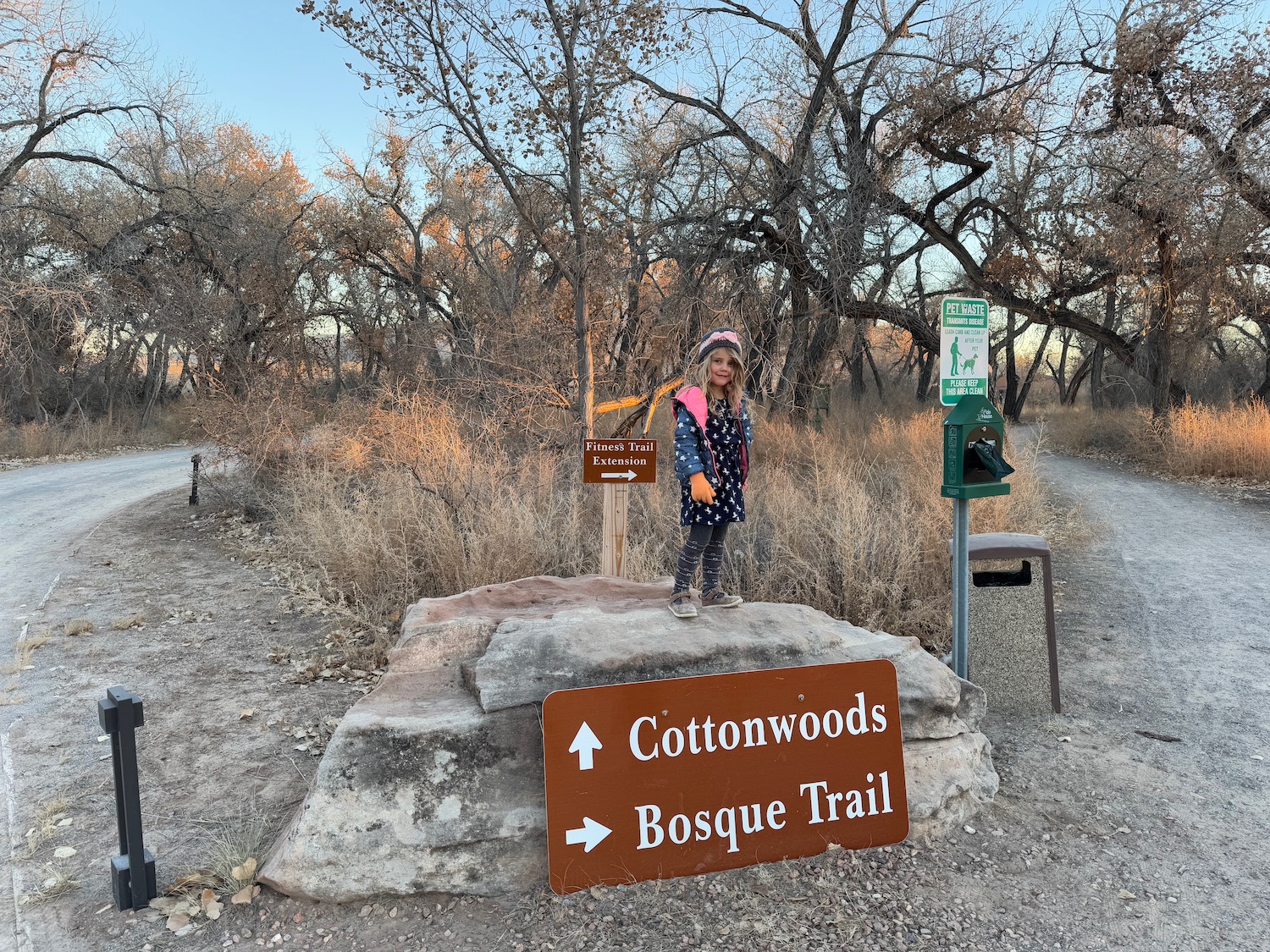 a girl standing on a rock next to a sign