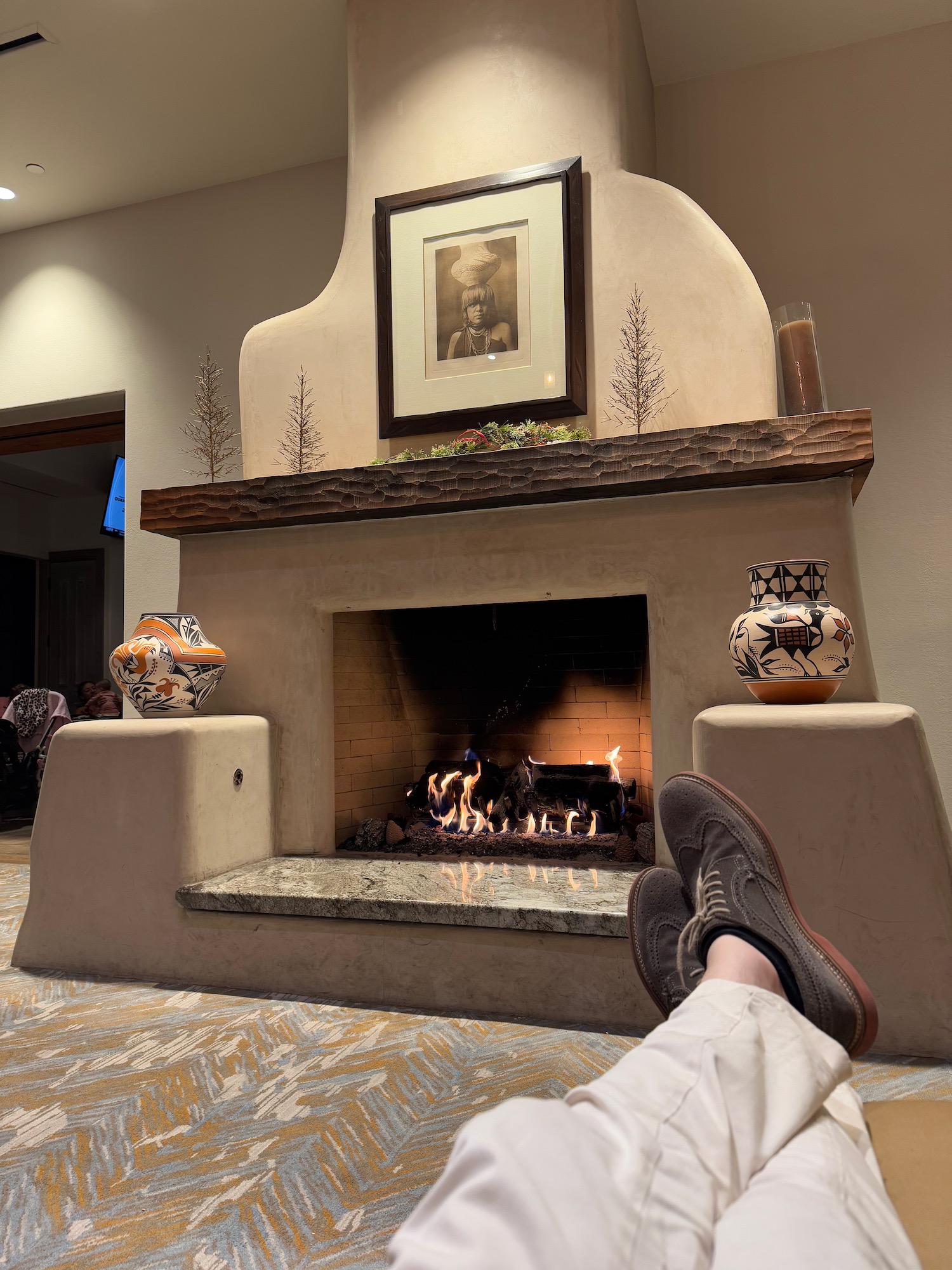 a person's feet in front of a fireplace