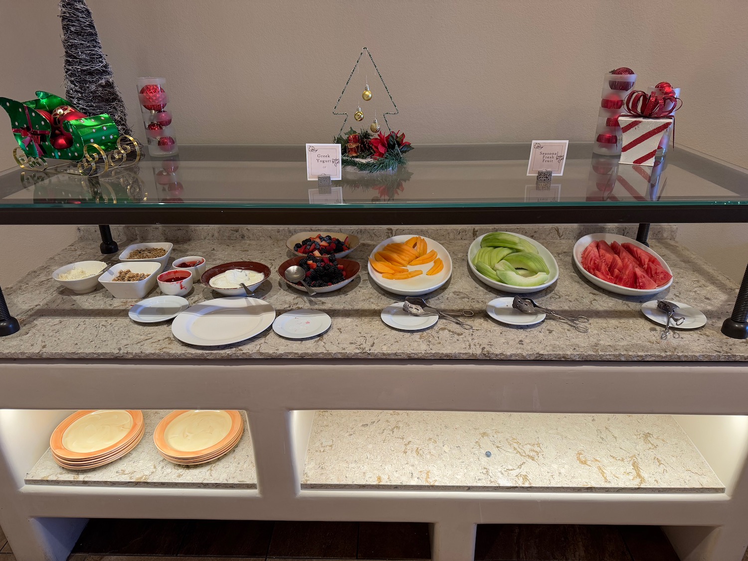 a buffet table with plates of fruit and desserts