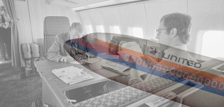 a man sitting at a desk in an airplane