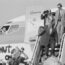 a man in a suit walking down a plane