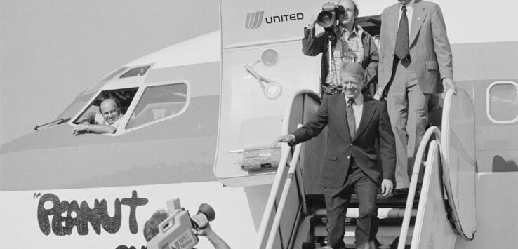 a man in a suit walking down a plane