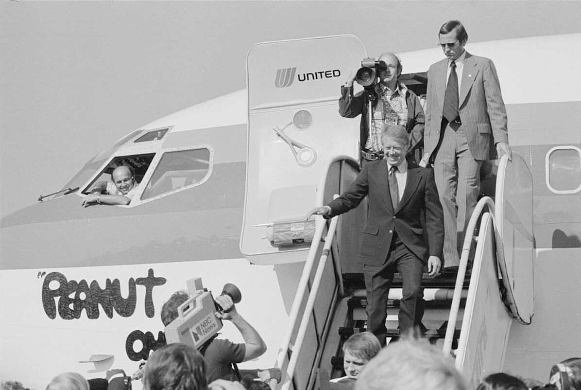 a man in a suit walking down a plane