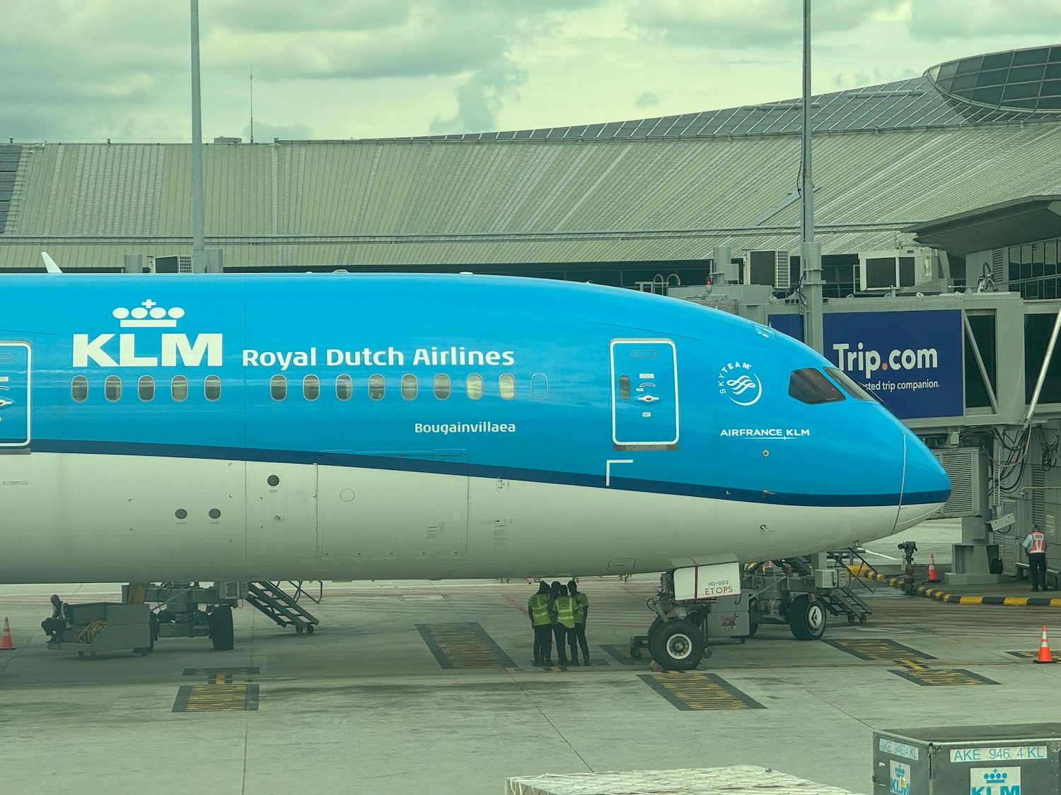 a blue and white airplane at an airport