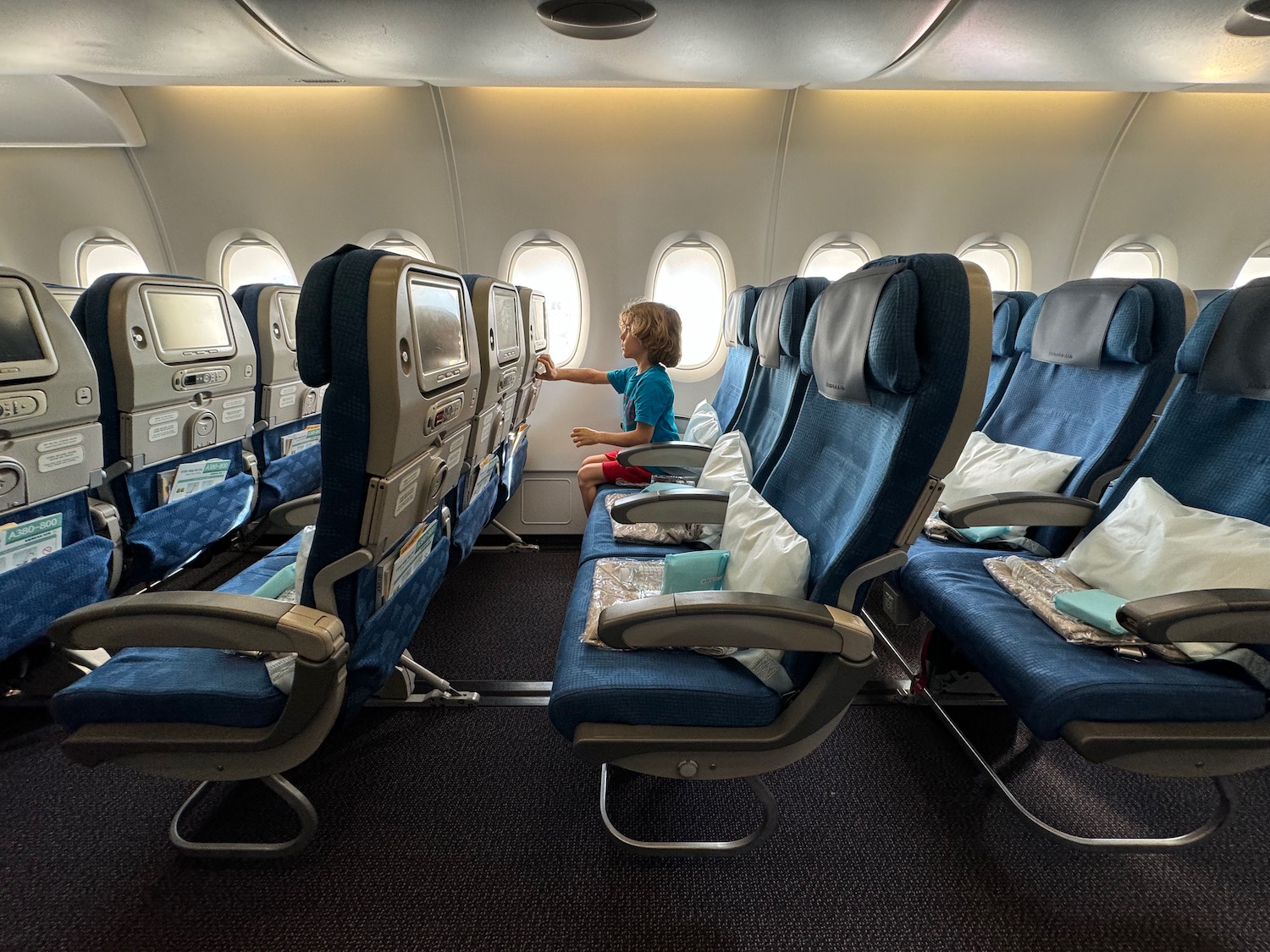 a child sitting on a seat in an airplane