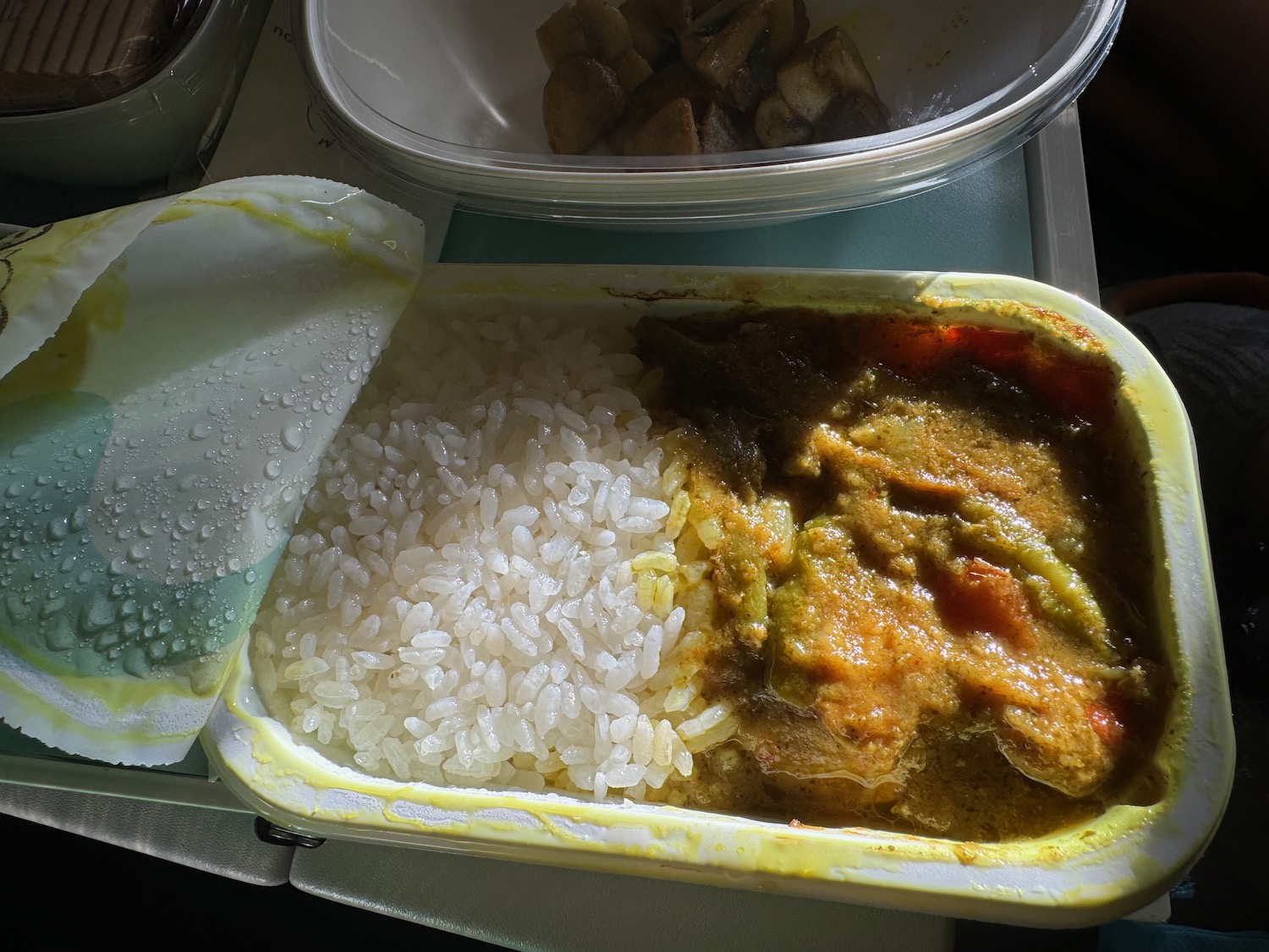 a container of food with rice and curry