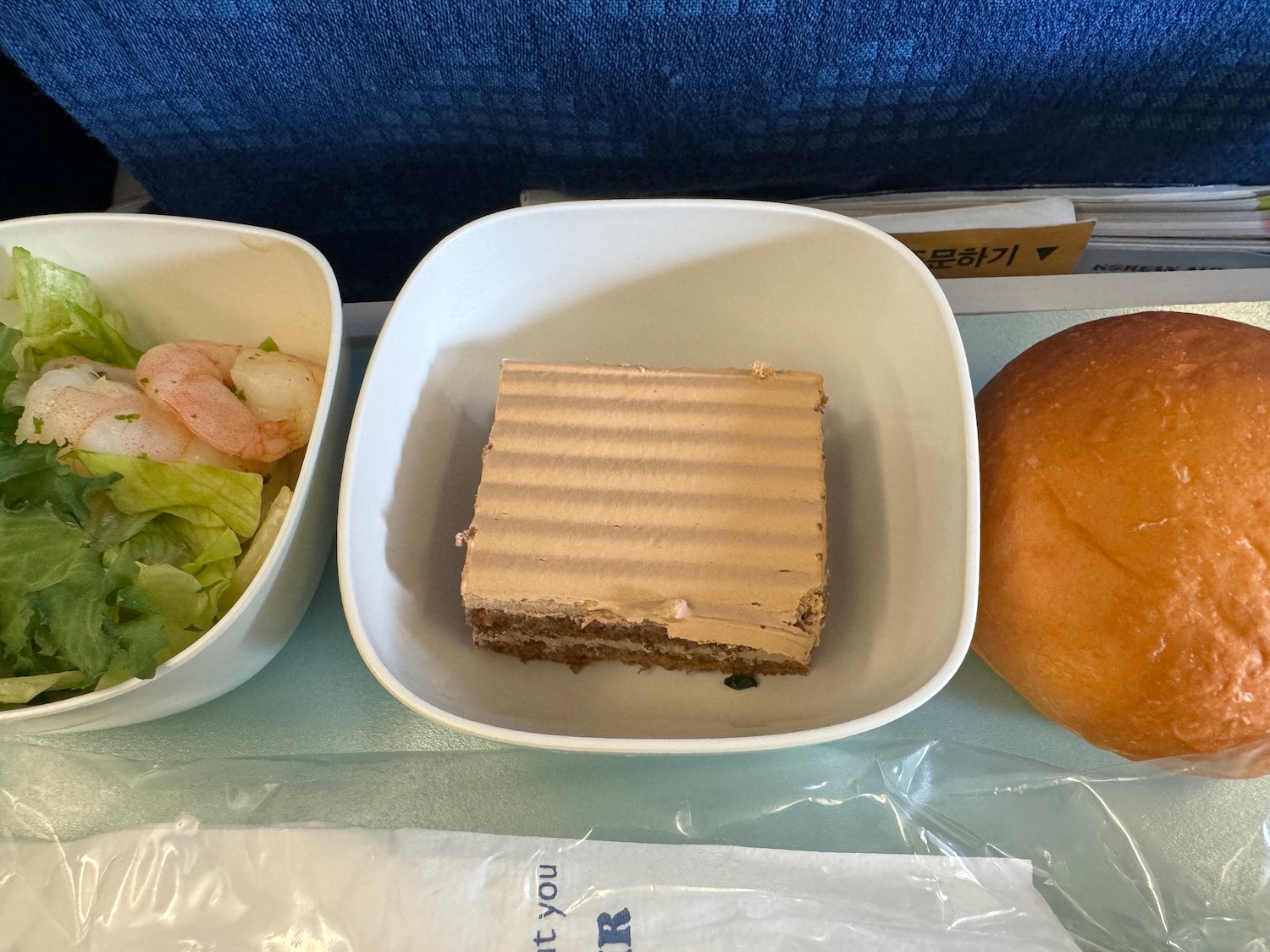 food in a bowl next to a sandwich and a bun