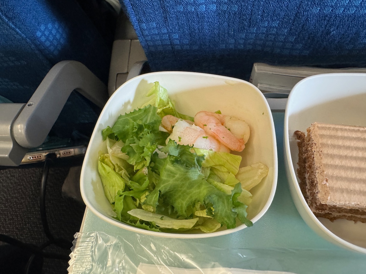 a bowl of salad and sandwich on a tray