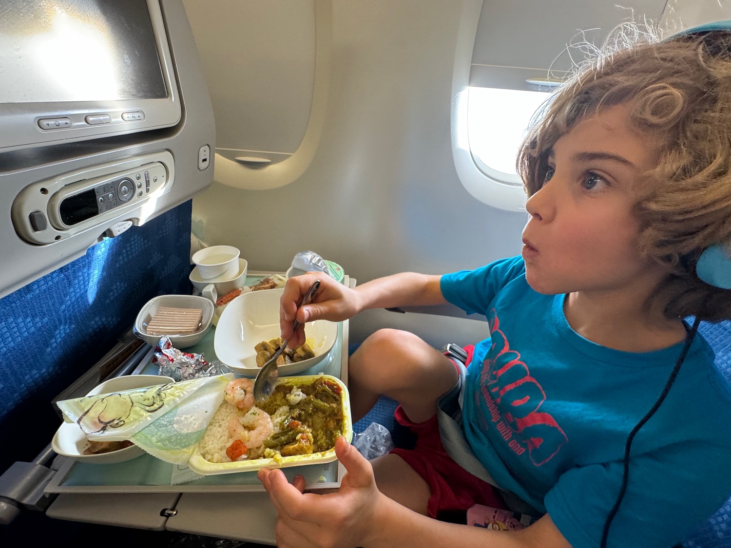 a child eating food on an airplane