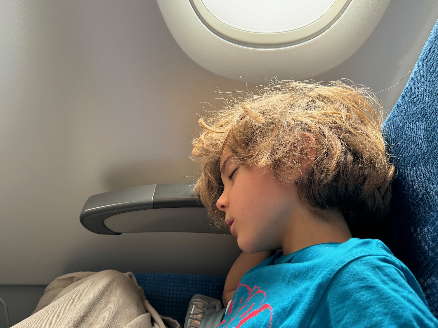 a boy sleeping on an airplane