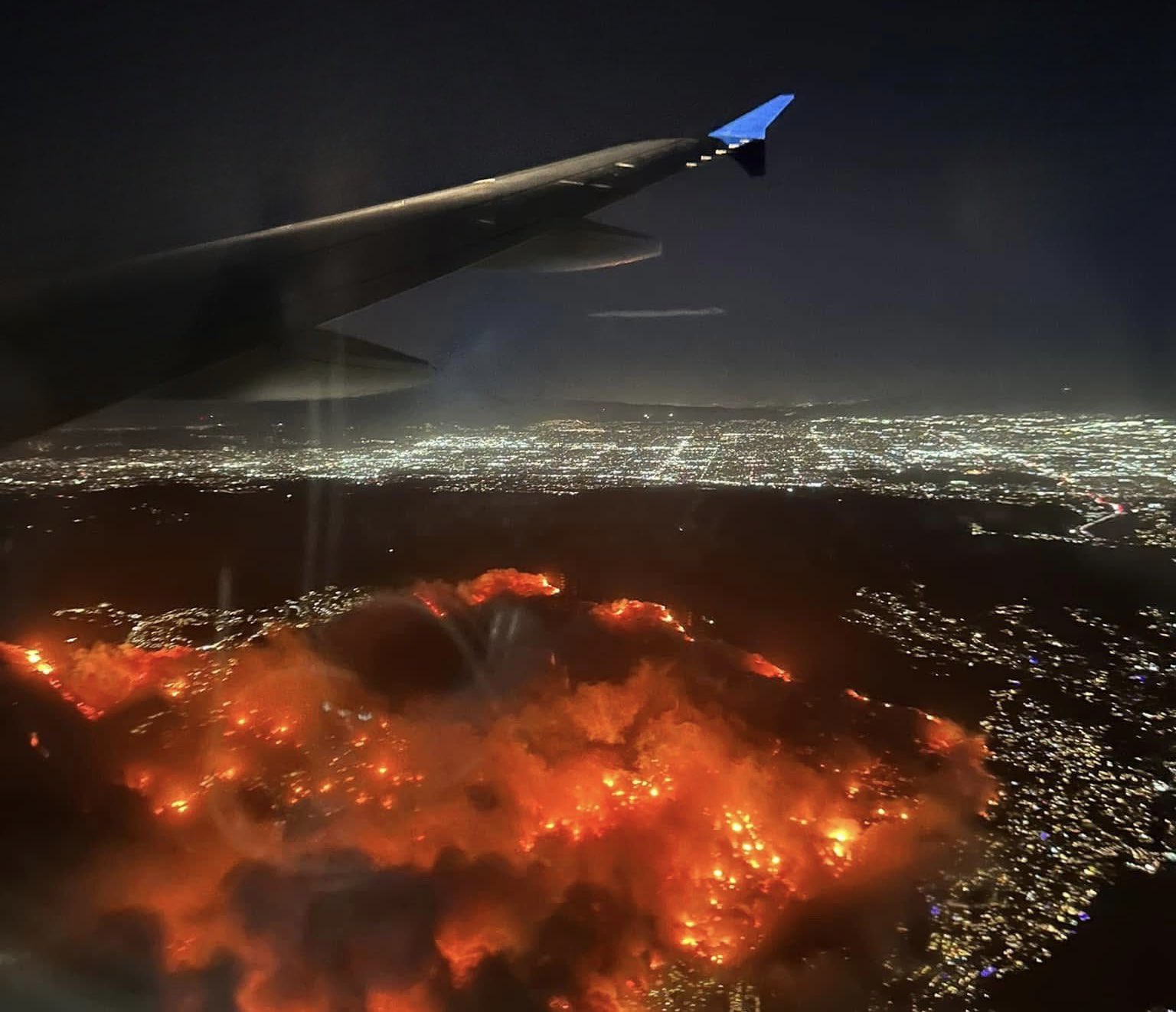 a view of a fire and a city from a plane