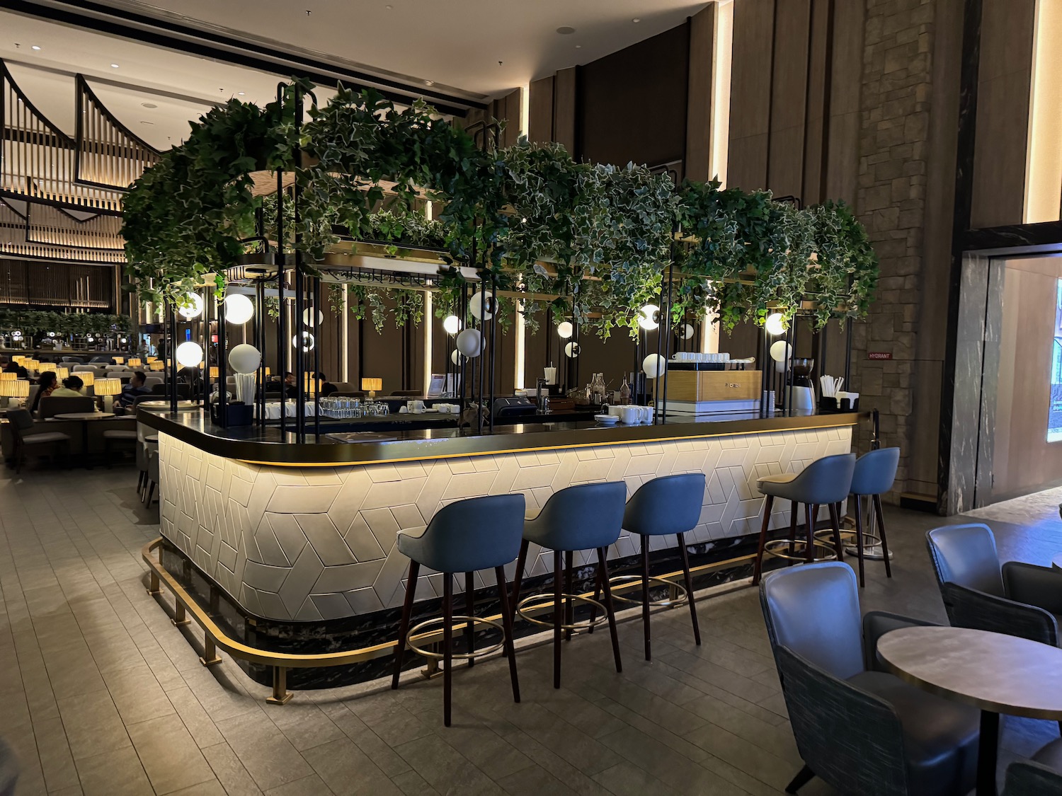 a bar with plants on top and chairs in a room