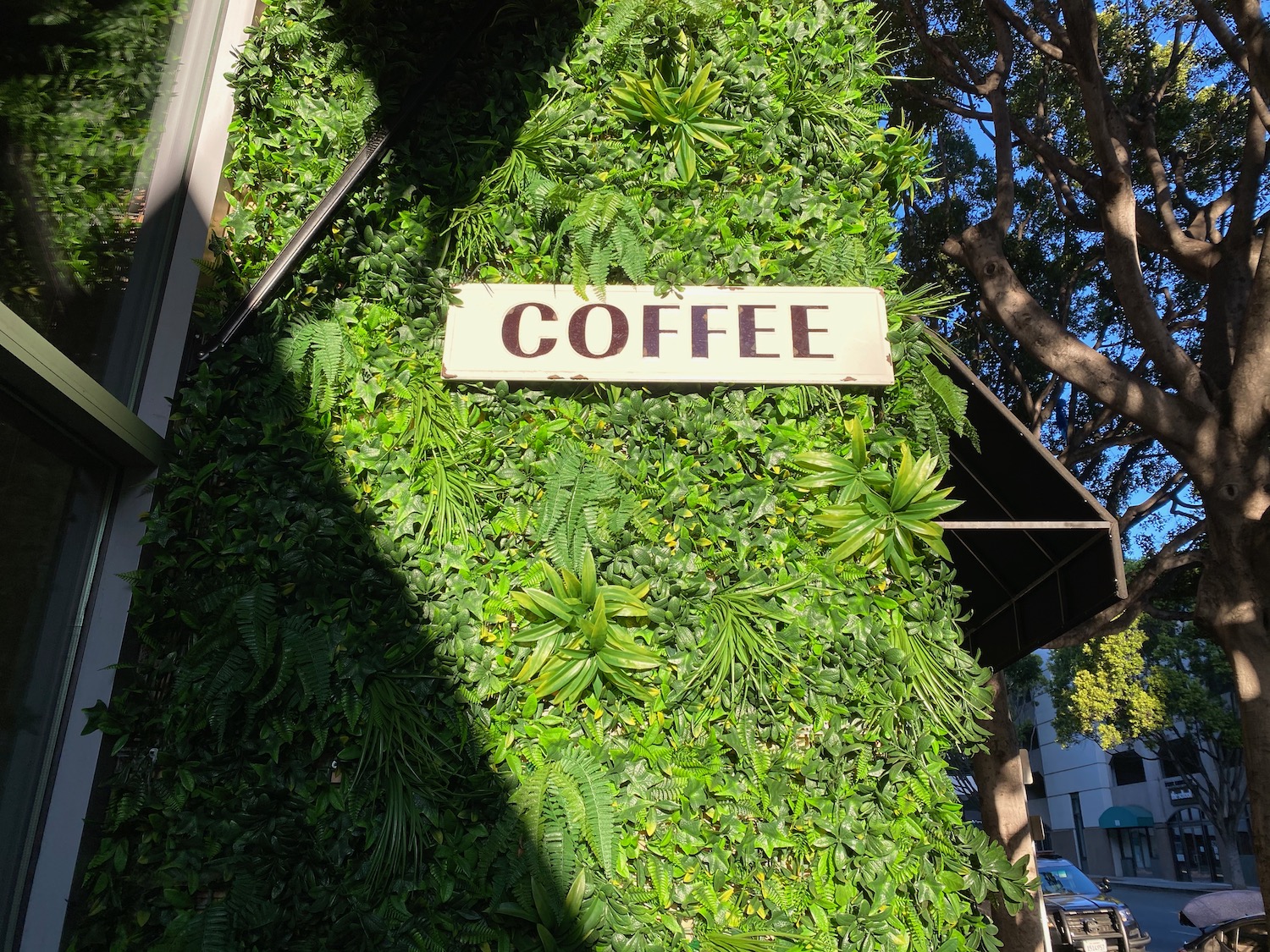 a sign on a wall of plants