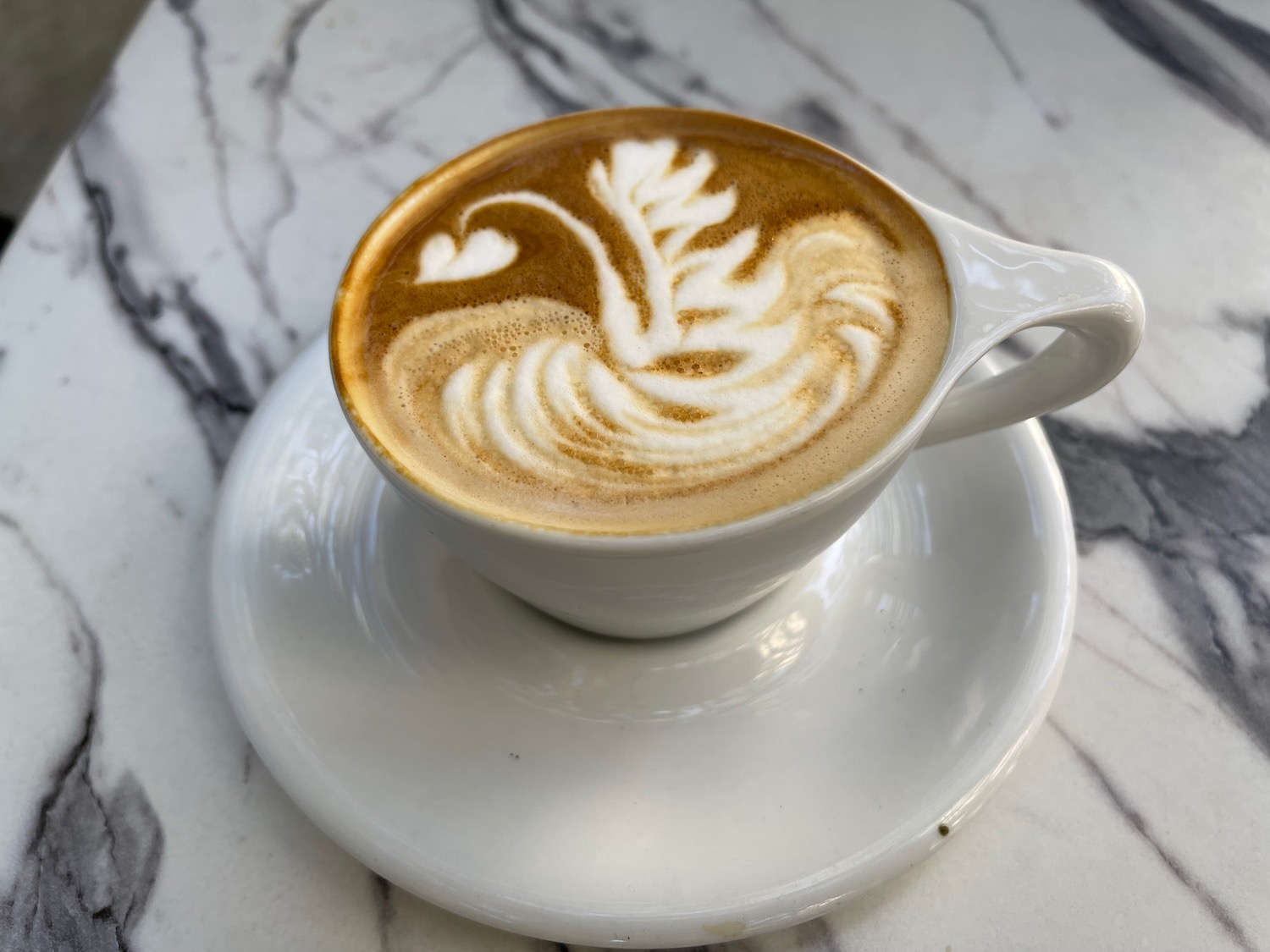 a cup of coffee with a swan design on top