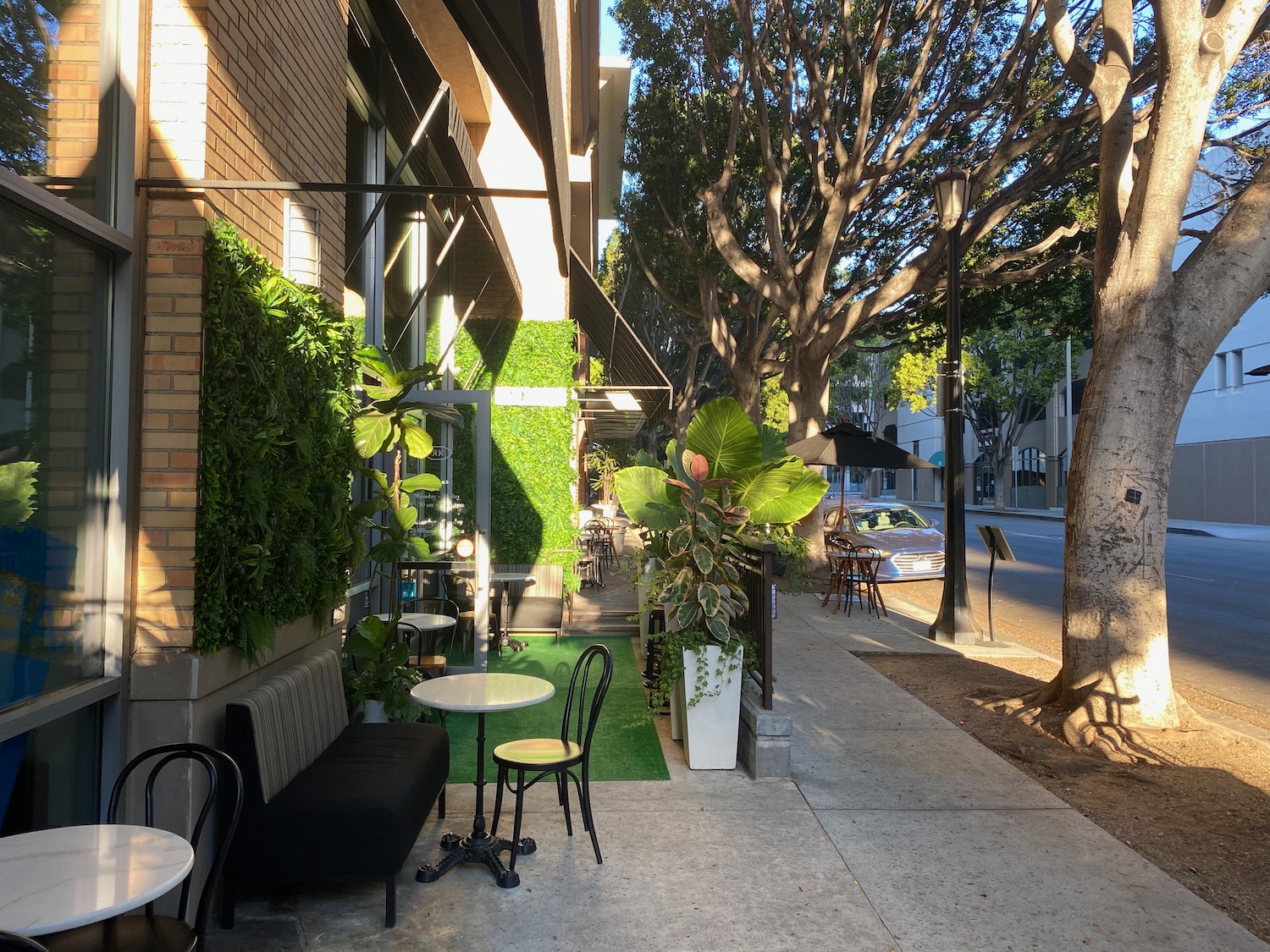 a sidewalk with tables and chairs on it