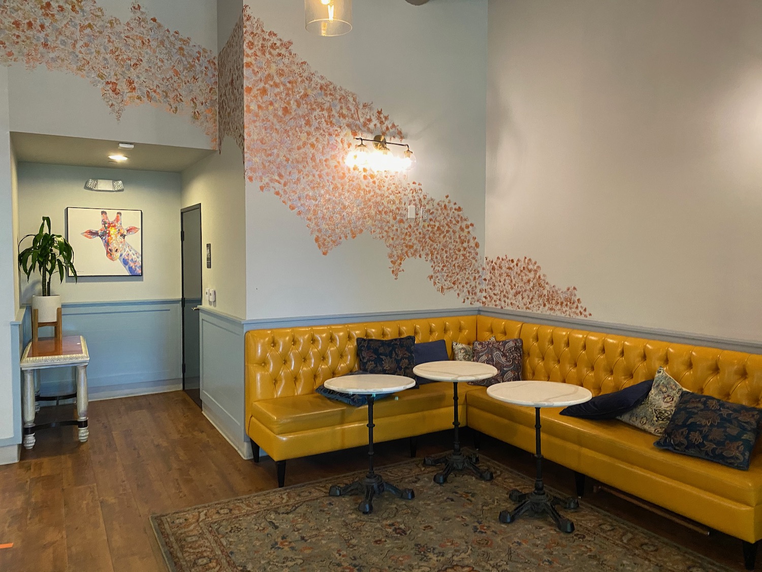 a yellow booth with tables and pillows in a room