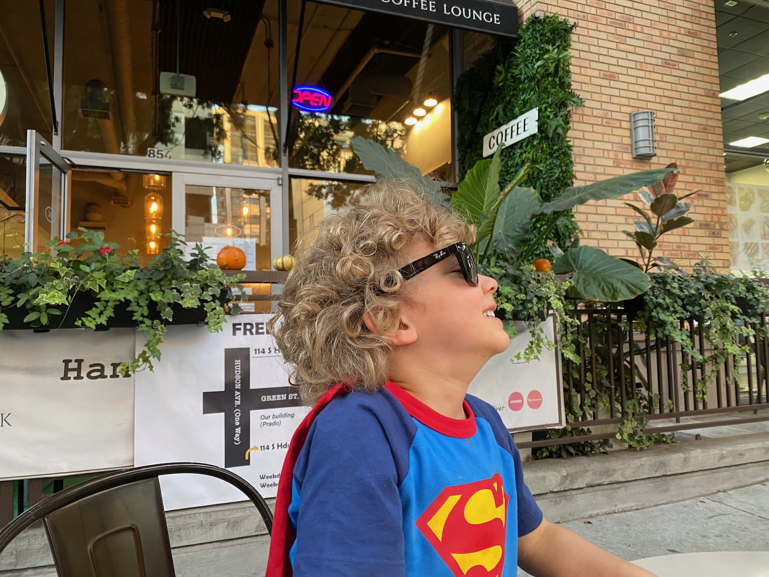 a boy wearing sunglasses and a superhero shirt