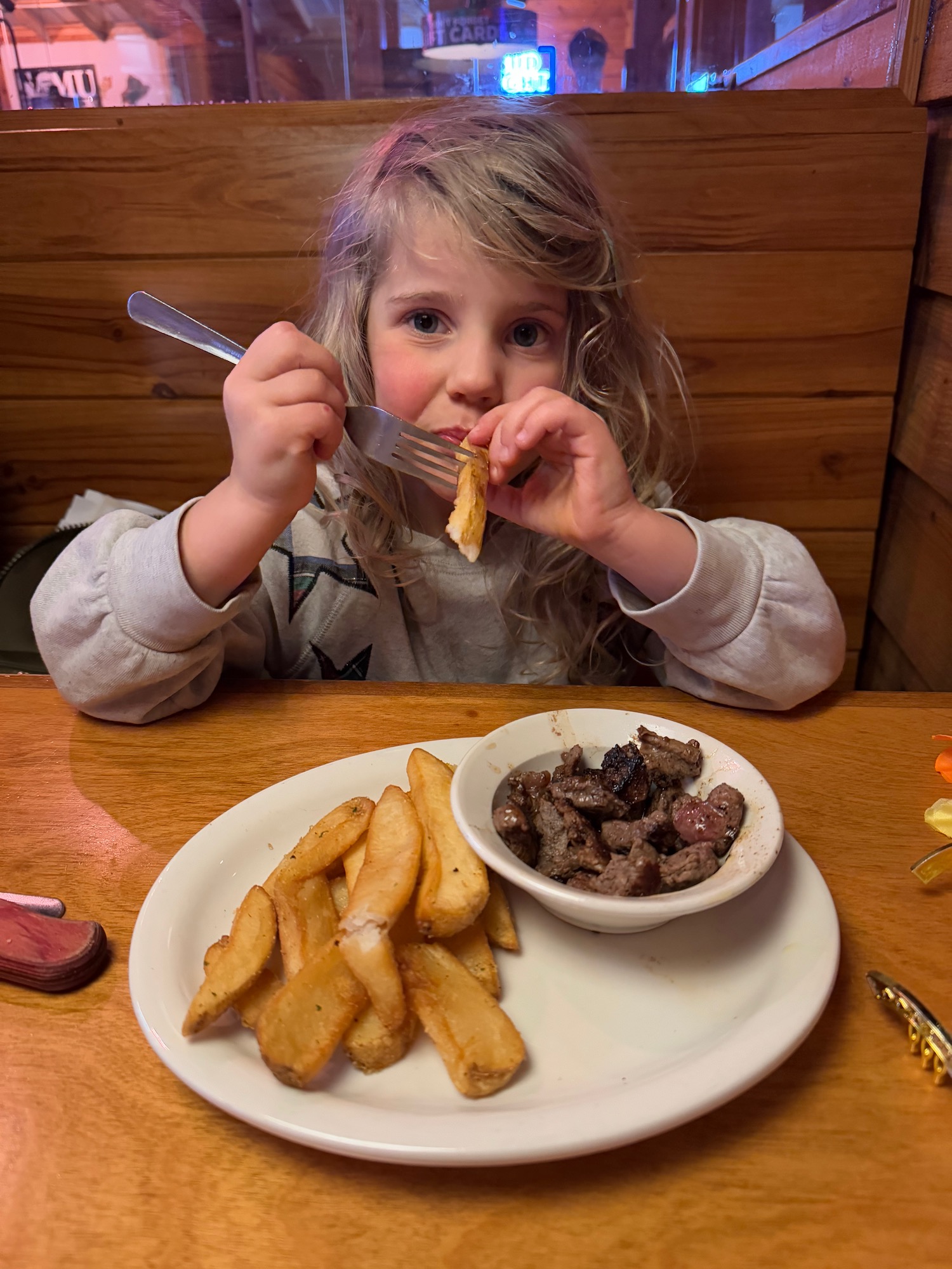 a girl eating food with a fork and knife