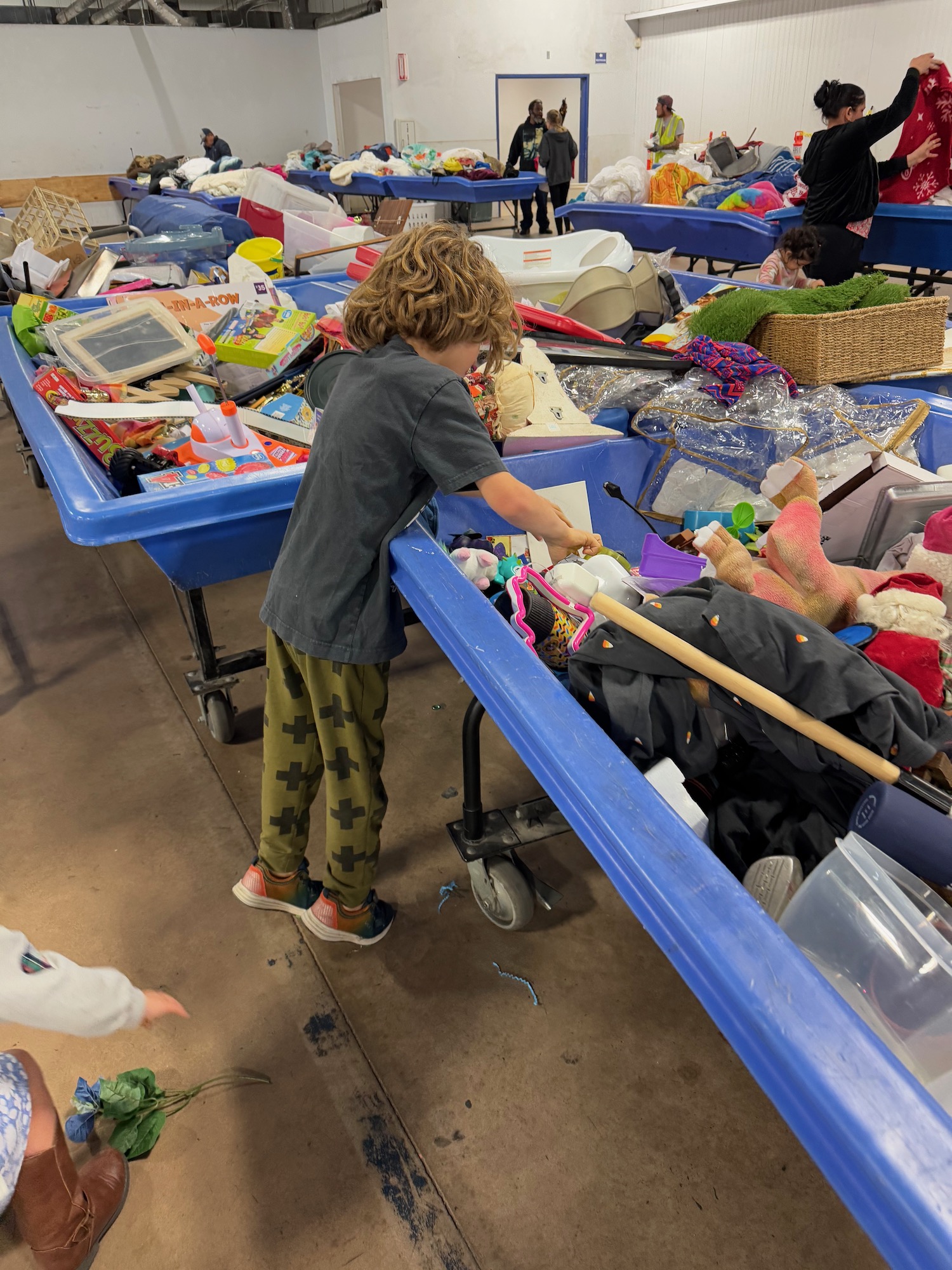 a boy standing on a cart with toys