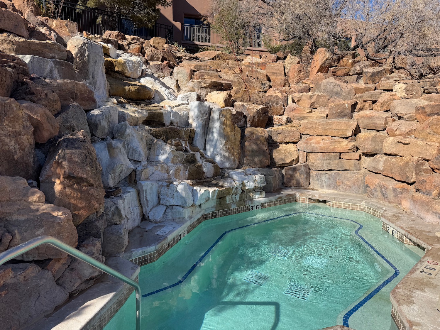 a pool with a waterfall and rocks