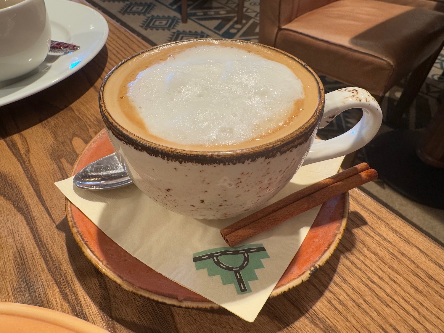 a cup of coffee with foam on a plate