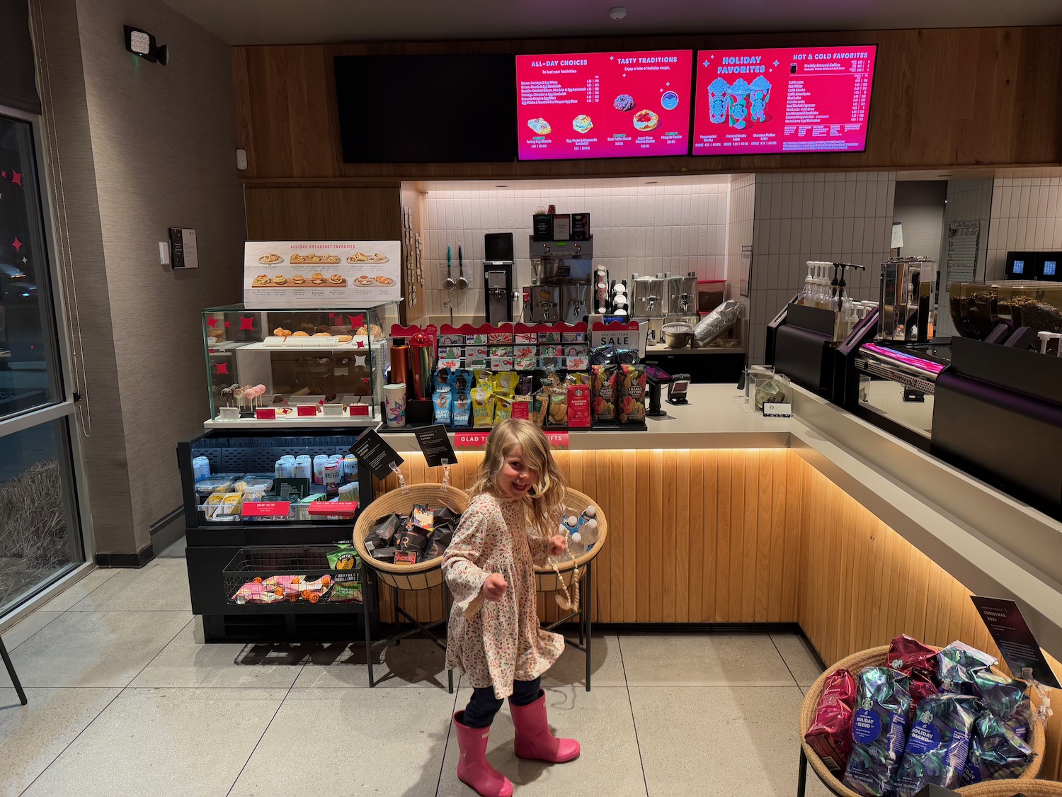 a girl standing in front of a counter with food and drinks