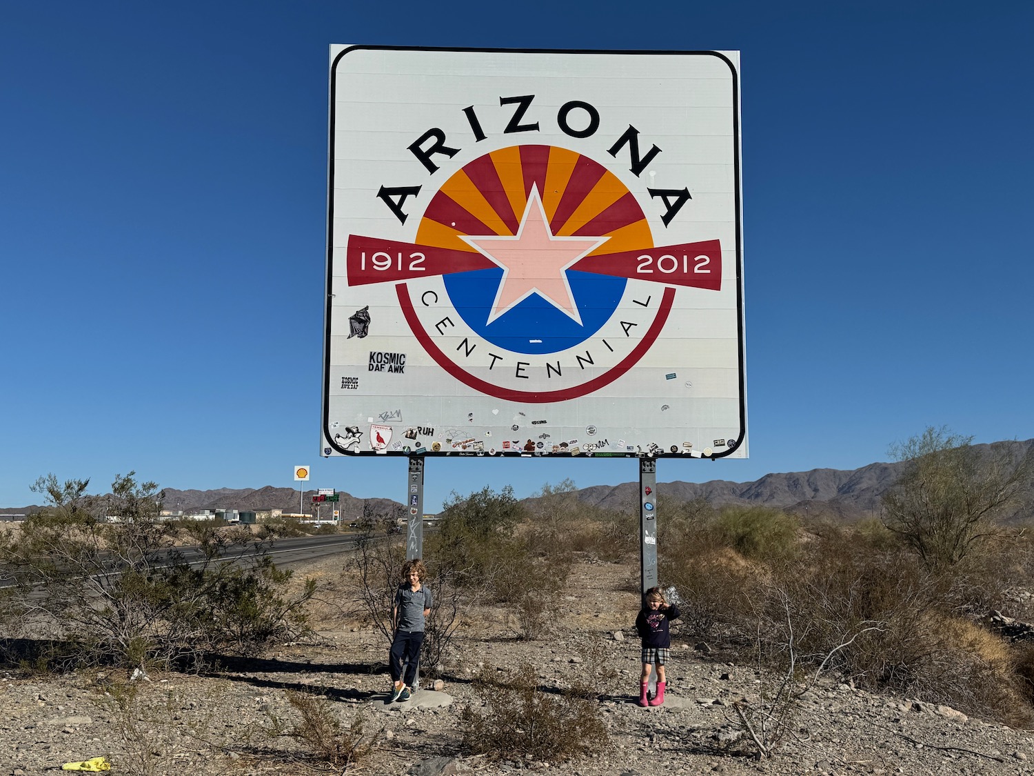 two children standing in front of a sign