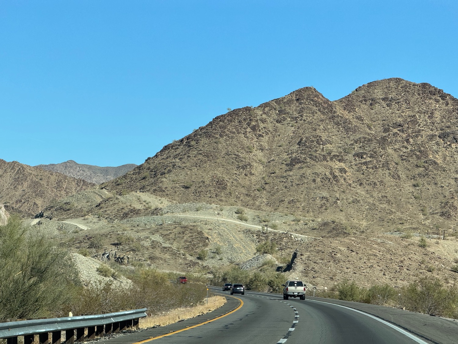 cars driving on a road with mountains in the background