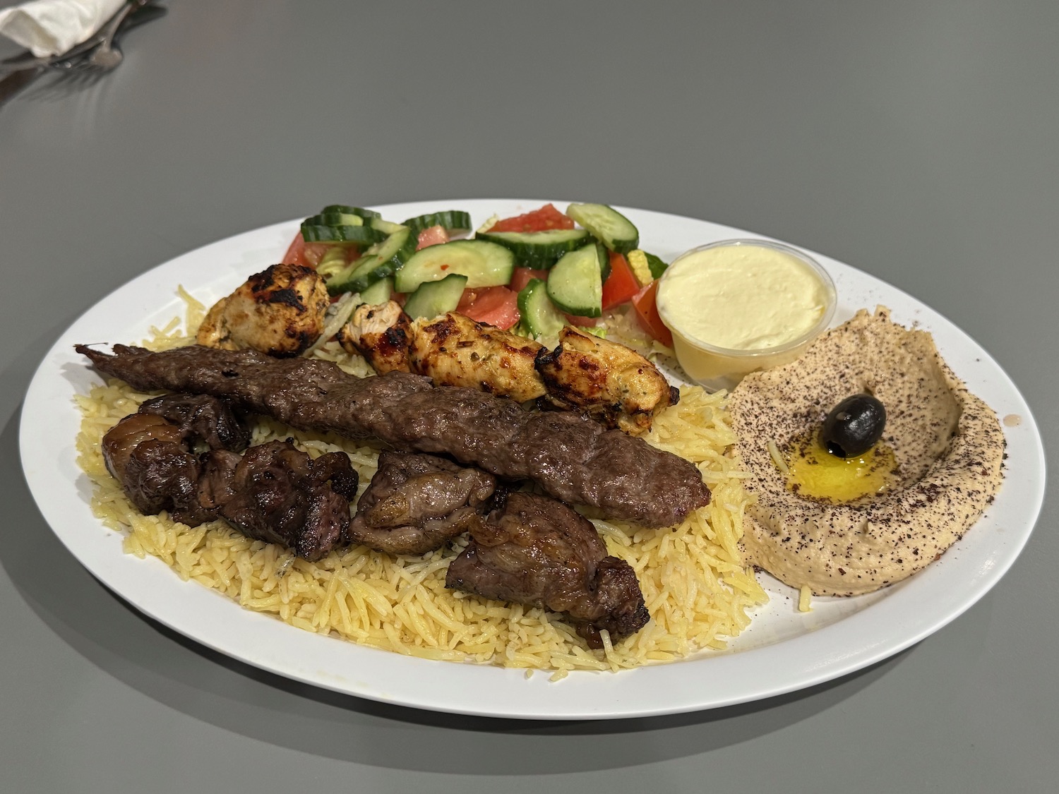 a plate of meat and rice with salad