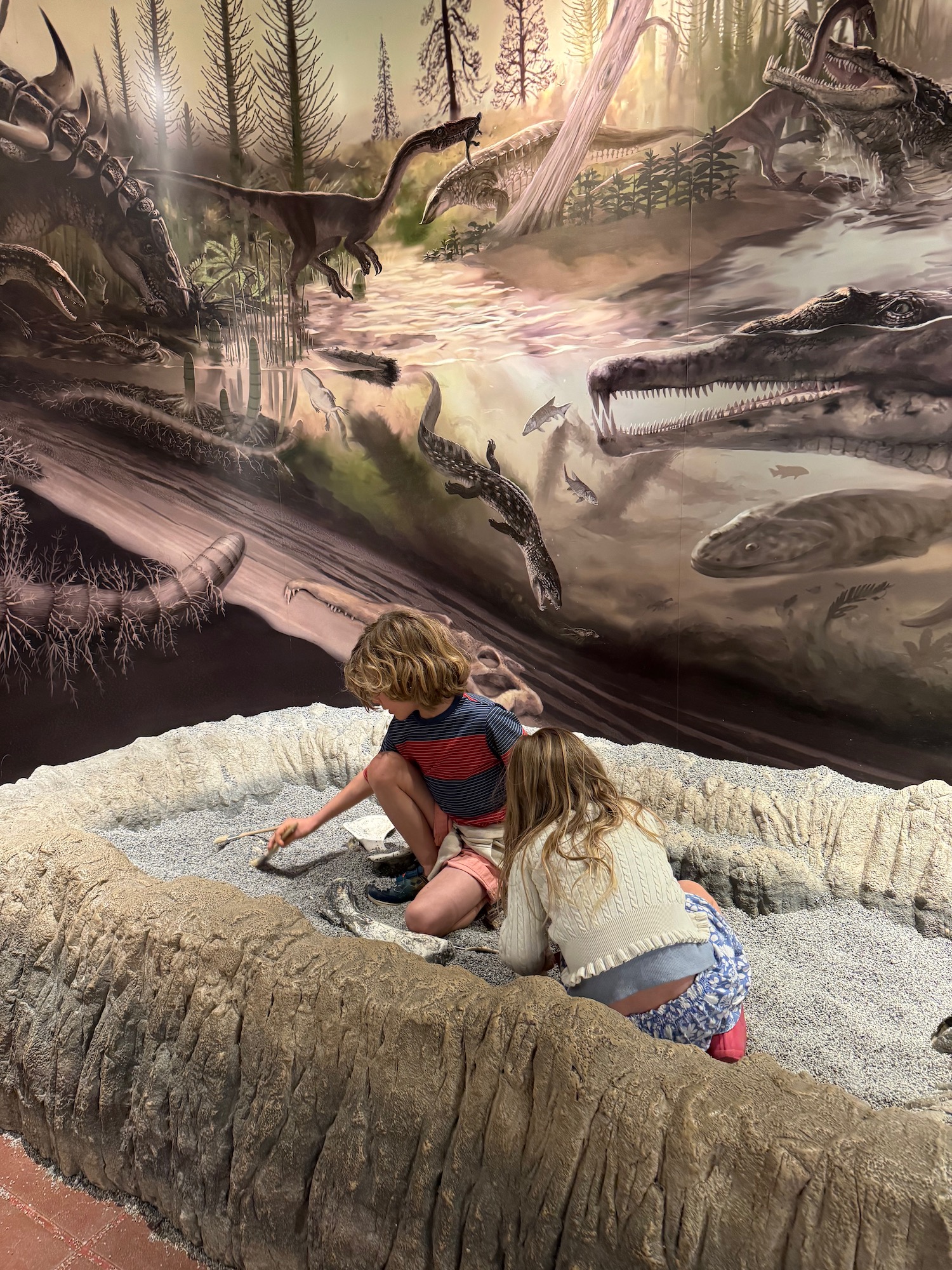 two children playing in a sand pit