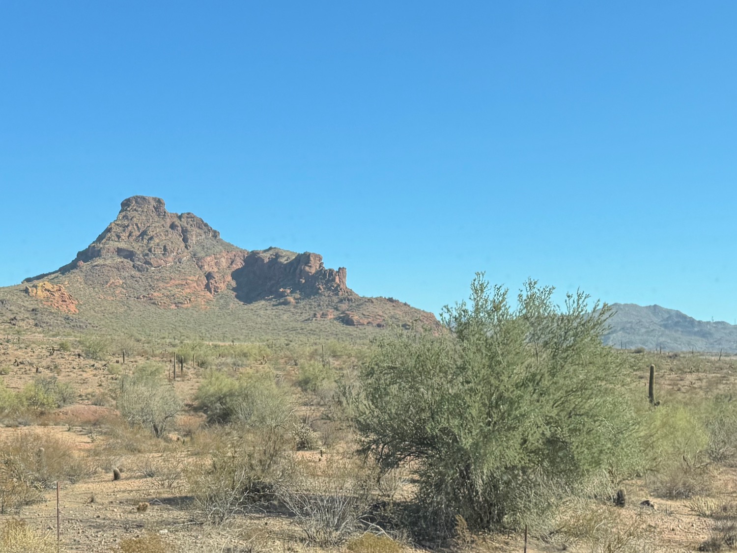 a desert landscape with a mountain in the background