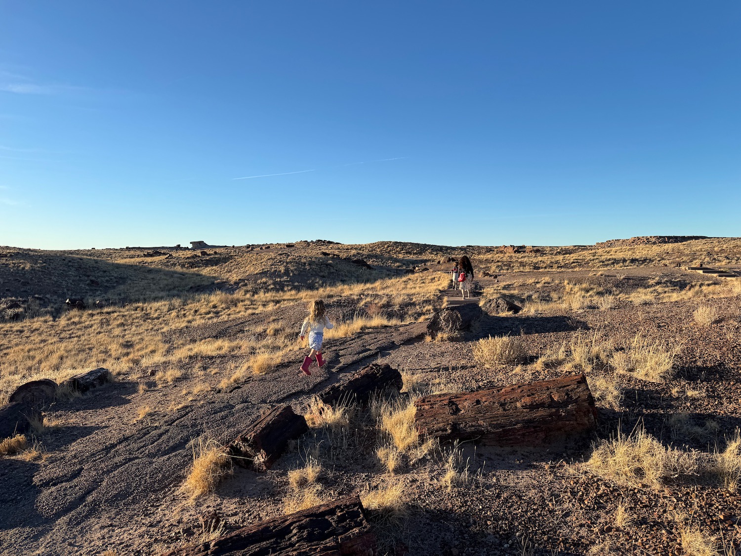 two people walking on a rocky hill