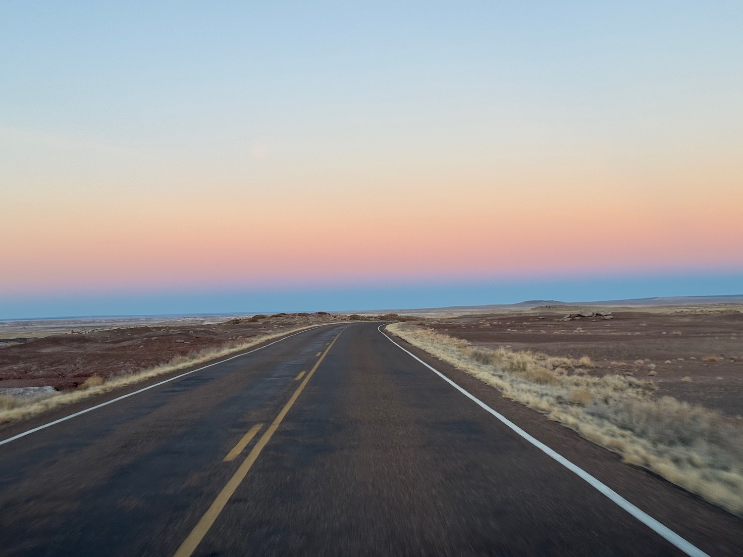 a road with a sunset in the background