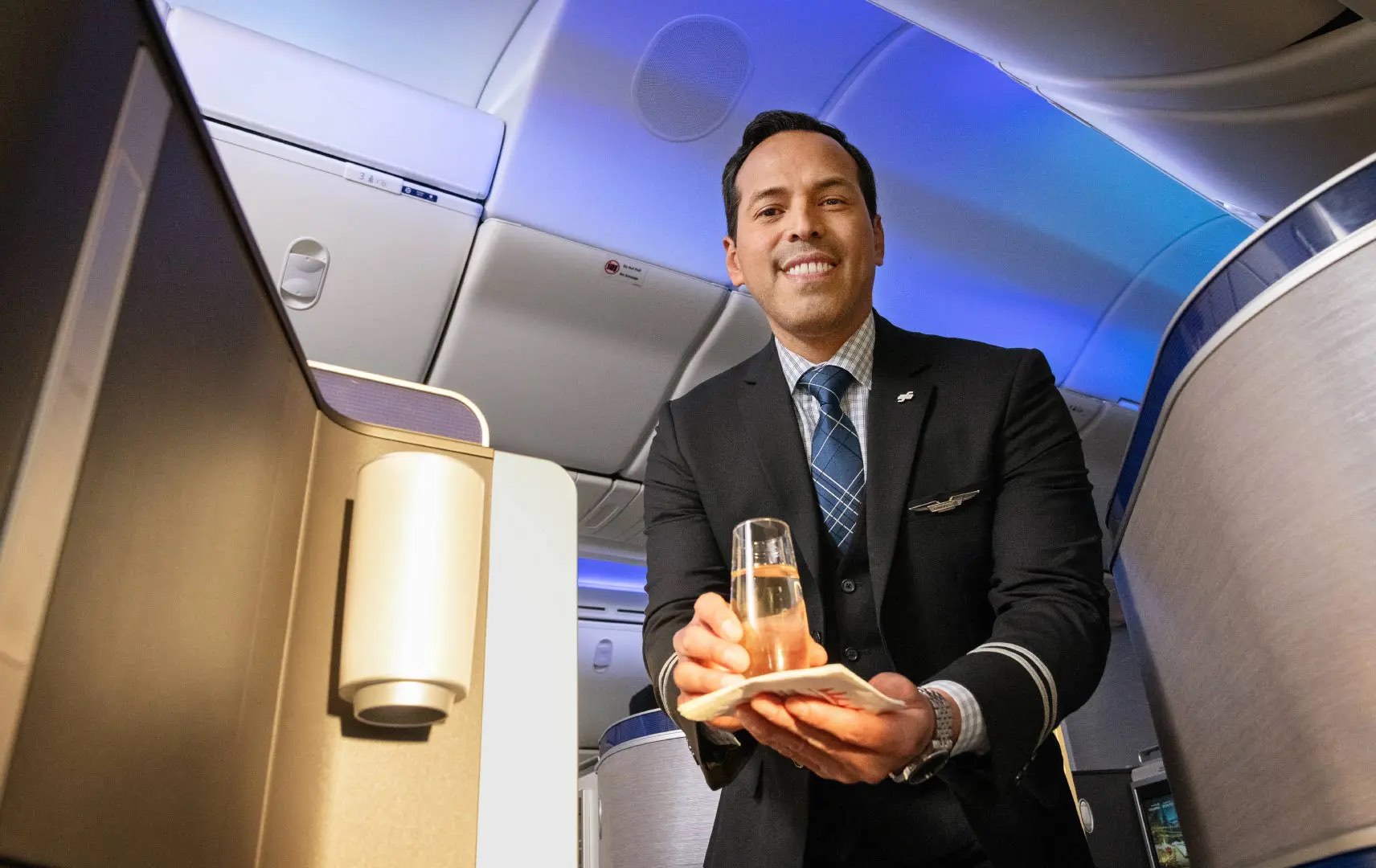 a man in a suit holding a glass of liquid