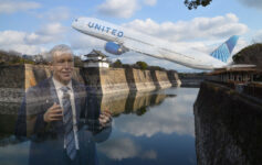 a man in a suit and tie standing in front of a body of water