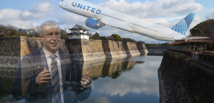 a man in a suit and tie standing in front of a body of water