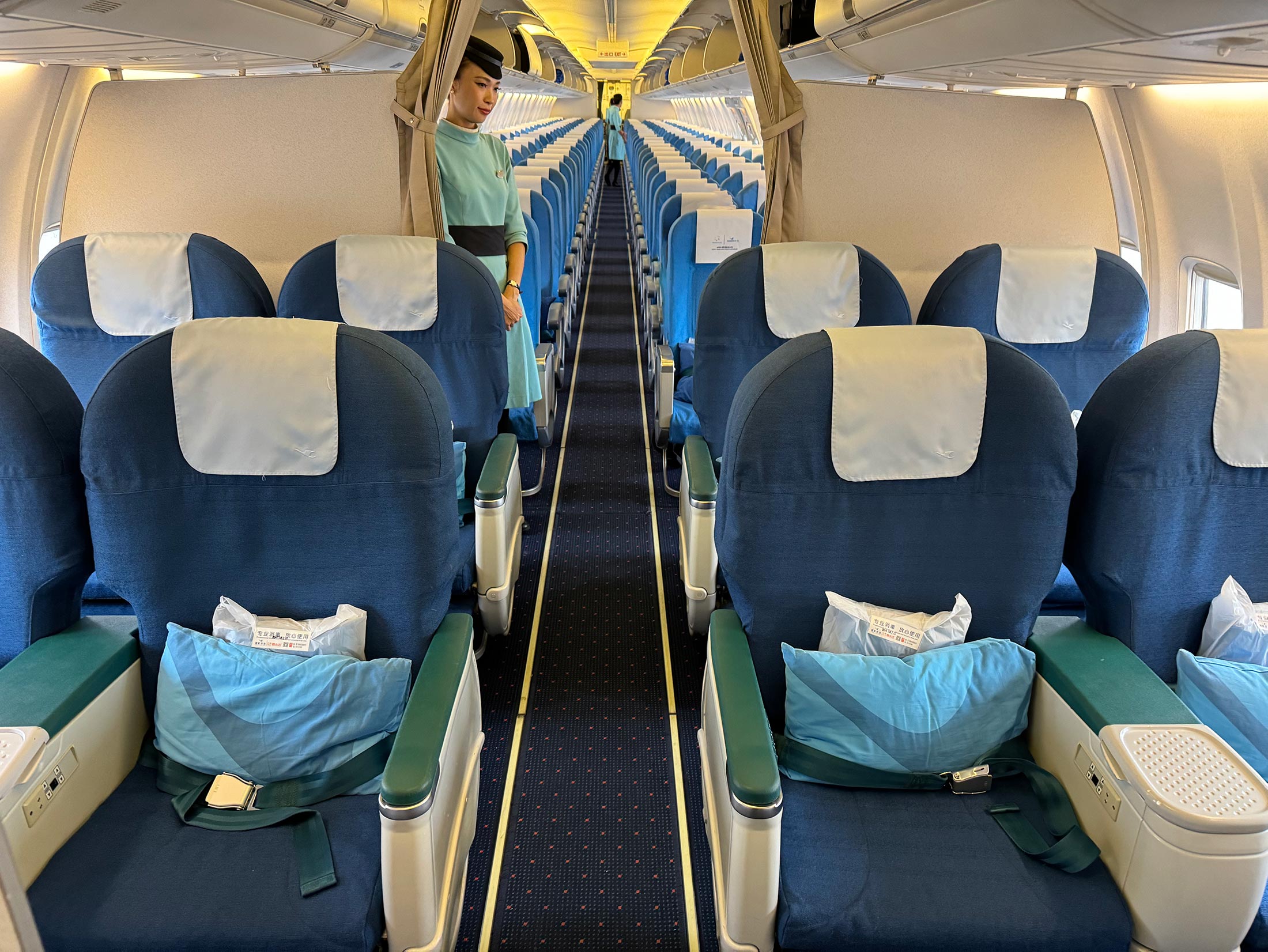 a woman standing in the aisle of an airplane