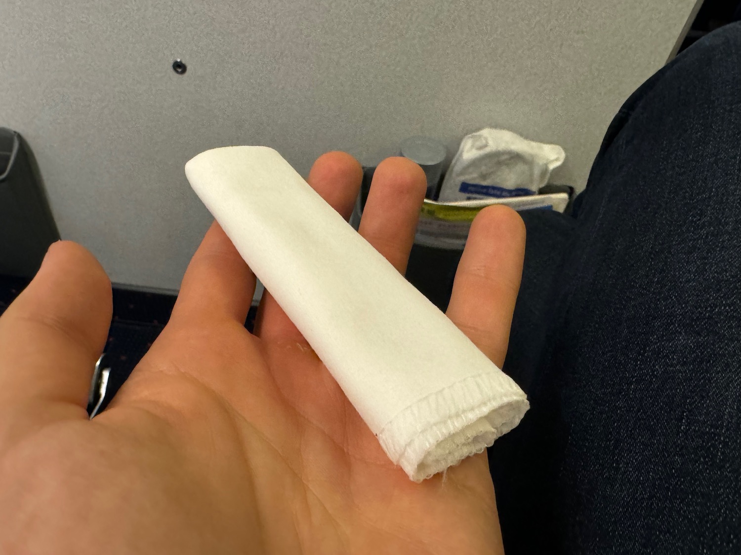 a hand holding a white roll of paper