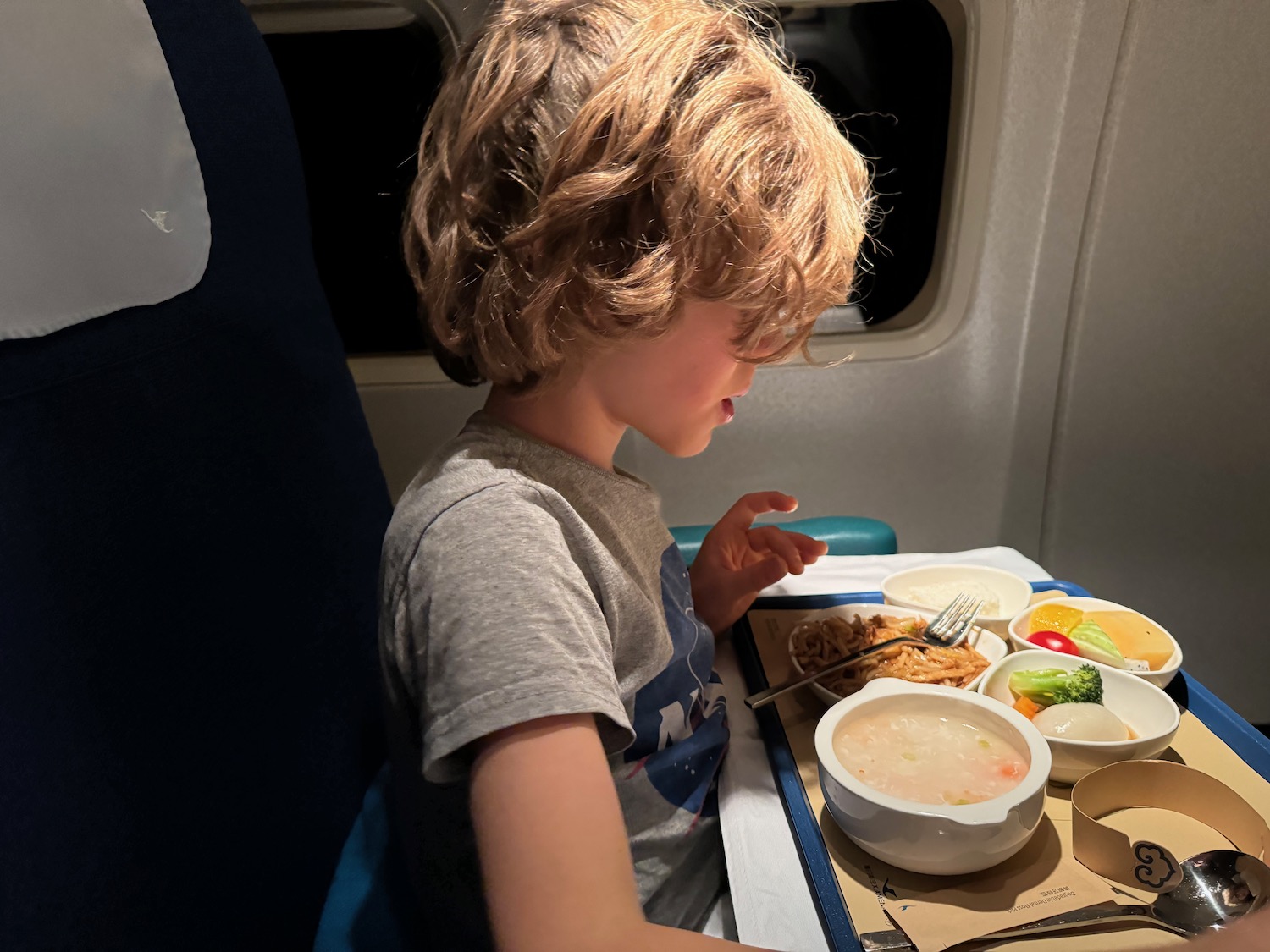 a child eating food on an airplane