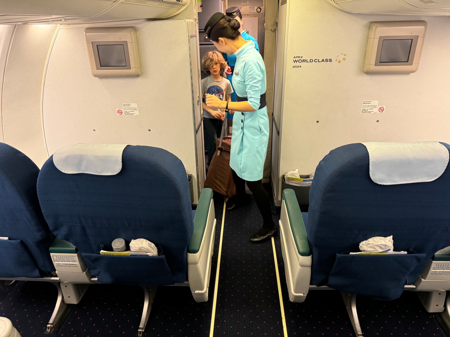 a woman standing in an airplane with a child