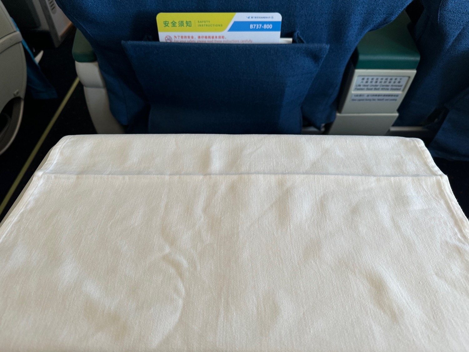 a white cloth with a pocket in the back of a seat