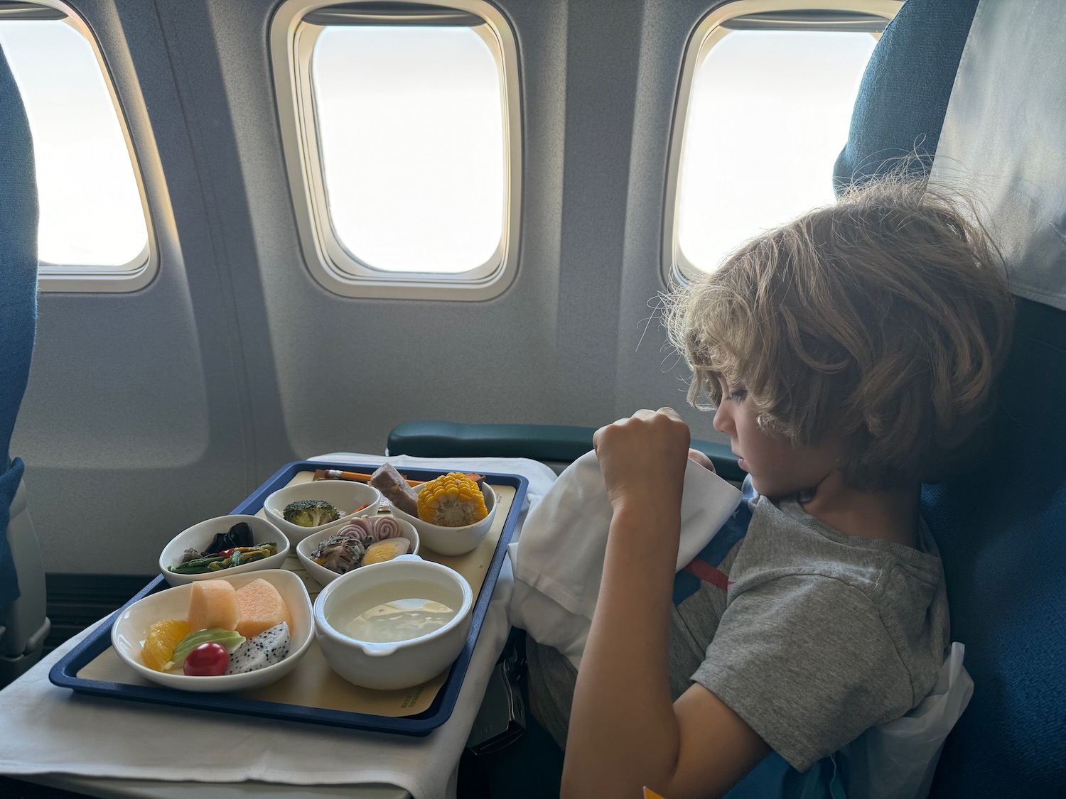 a child sitting in a chair with food on the table