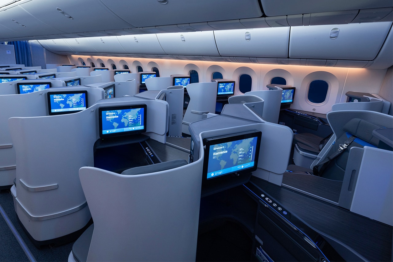 a row of seats with monitors on the side